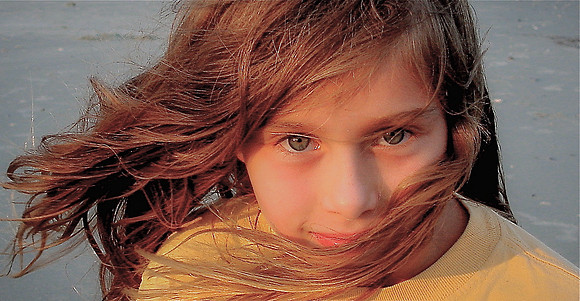 Girl with blown hair, windy sunset, Folly Beach SC